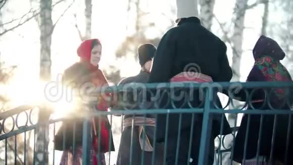 俄罗斯传统阳光明媚的日子里人们穿着漂亮的衣服在桥上跳舞视频的预览图
