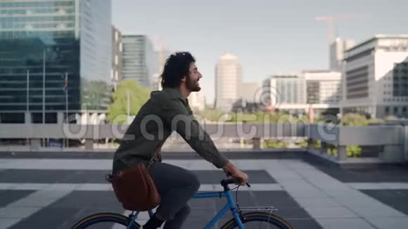 成功的微笑职业年轻人骑自行车在现代建筑前的背景视频的预览图