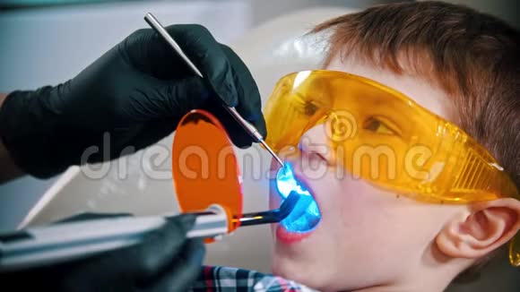 一个戴着防护眼镜的小男孩他的牙齿做了嘴里有光聚合物灯视频的预览图