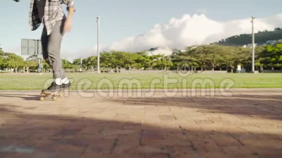 男滑板手在公园的滑板上平衡脚滑板手在公园里玩把戏视频的预览图