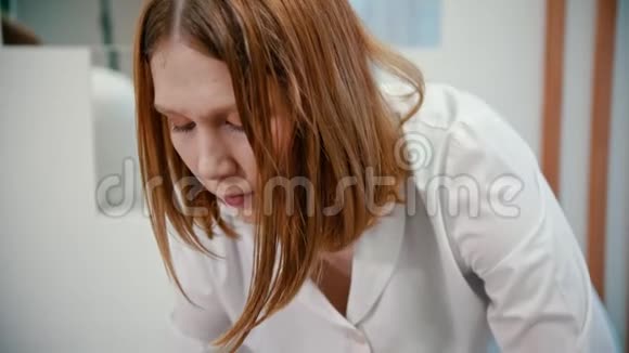 按摩女性按摩治疗师使用不同的技术按摩红发年轻女性的面部视频的预览图