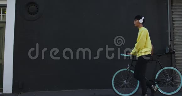 跨性别成人步行与自行车和耳机视频的预览图