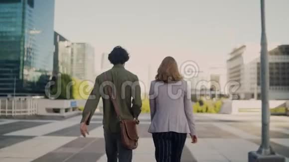 一位商人和女商人在街上漫步的后景城市背景是现代建筑视频的预览图