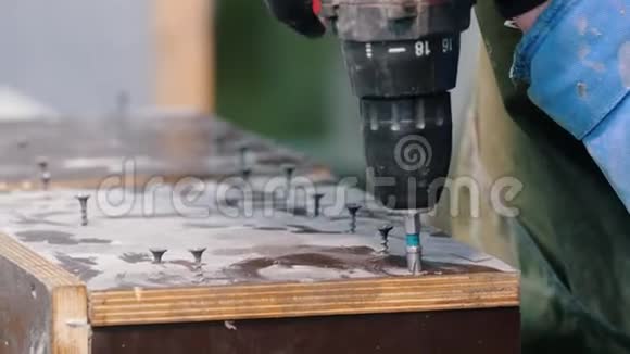 混凝土车间一个人用螺丝刀把螺栓拧成木制表面视频的预览图