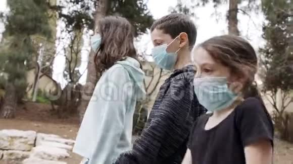 冠状病毒大流行儿童带着口罩在户外行走避免传染视频的预览图