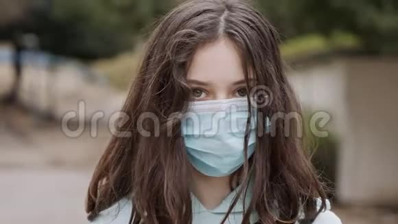 冠状病毒大流行于戴面罩的女孩脸上避免传染视频的预览图