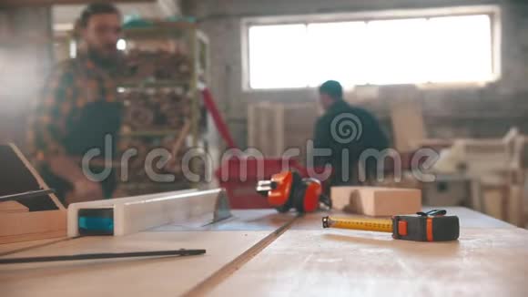 在木工车间工作的男人桌子上的不同物品视频的预览图
