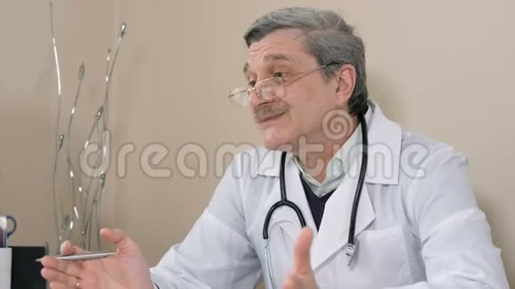 友好专业男儿科医生穿白大褂跟男童病人讲解医疗视频的预览图