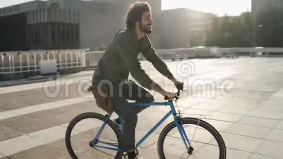 阳光明媚的一天快乐的年轻人背着书包骑自行车视频的预览图