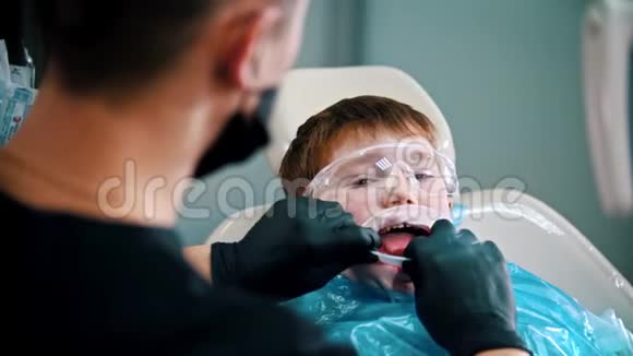 一个正在做牙齿的小男孩戴上开口器视频的预览图