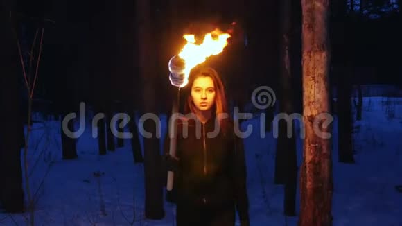 冬天森林里一位手持火炬的美女走到镜头前视频的预览图