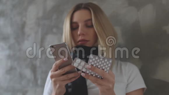 一个女人一只手拿着手机另一只手拿着一簇平板电脑站在灰色的背景下一个女孩视频的预览图