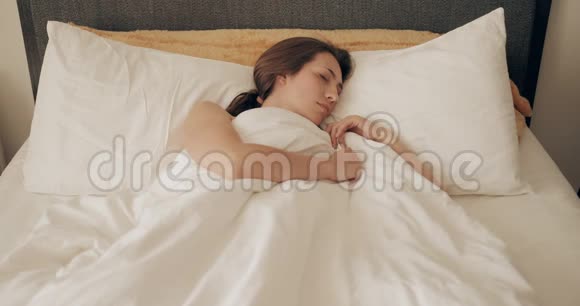 令人震惊的年轻漂亮女人睡过头了躺在床上起床很快美丽的女孩醒来视频的预览图