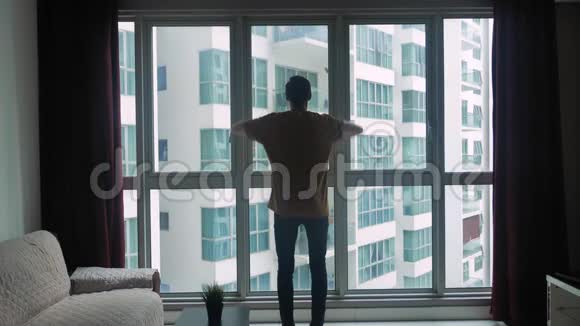 年轻人的剪影看着房间的窗户举起手来梦想和成功的概念视频的预览图