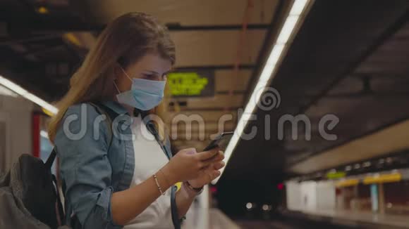 地铁车站的年轻女子戴着冠状病毒面罩视频的预览图