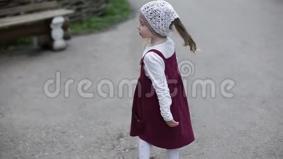 穿着裙子在公园里散步的小女孩视频的预览图