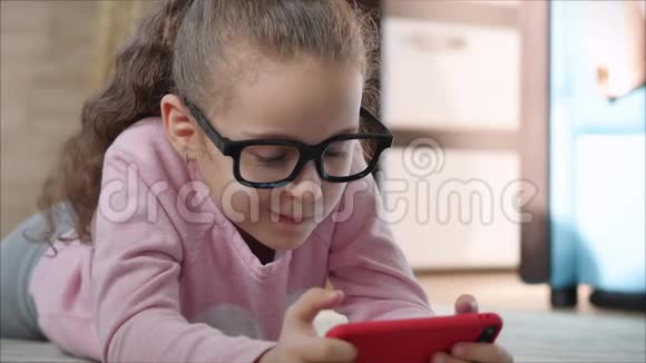可爱的婴儿用手机或平板电脑娱乐小女孩把空闲时间花在玩手机游戏上玩得很累视频的预览图