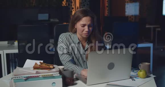 年轻压力大的女人在夜间办公室工作时看起来疲倦和倦怠精疲力竭的女孩惊慌失措视频的预览图