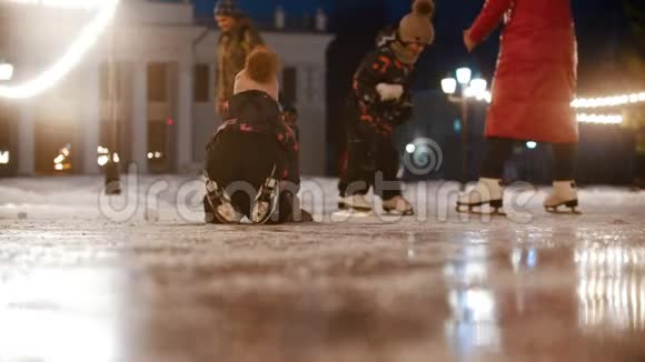 一个小孩跪在公共冰场上爬行视频的预览图
