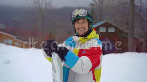 一个年轻人戴着头盔和滑雪板在一个山地度假活动公园的特写镜头寒假视频的预览图