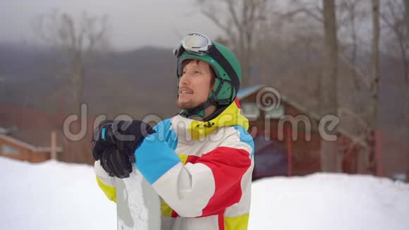 一个年轻人戴着头盔在一个山区度假胜地用滑雪板拍摄的特写镜头寒假概念滑动视频的预览图