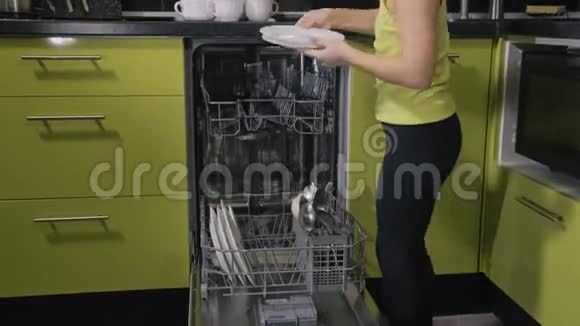 聪明的女孩学会用洗碗机时尚现代内置绿色黑色厨房用具孩子把脏东西视频的预览图