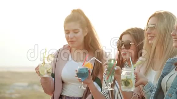 群笑女孩朋友夏天都市喝着彩色鸡尾酒又笑慢动作视频的预览图
