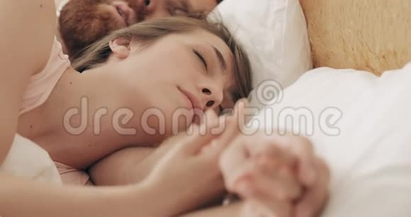 在清晨睡觉时亲密的情侣在床上拥抱英俊的长胡子男人拥抱女孩视频的预览图