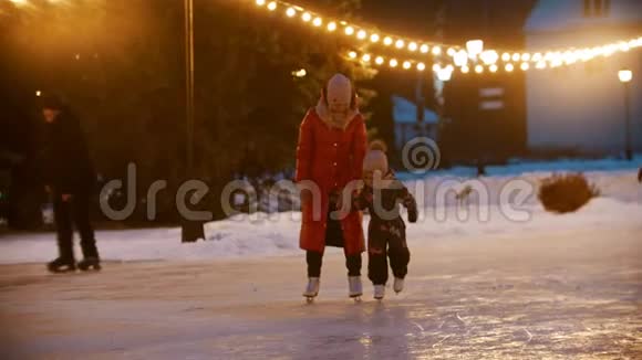 一个年轻女子带着女儿在溜冰场溜冰视频的预览图
