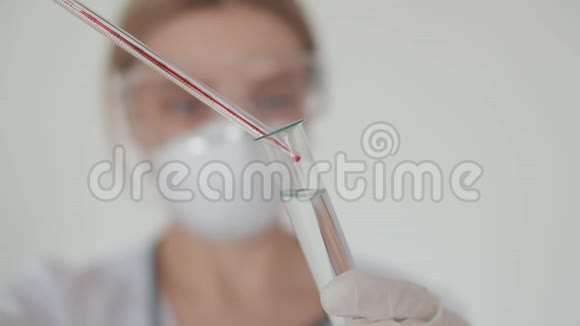 一位年轻的实验室工作人员对一个患有冠状病毒的人进行了血液测试一个试管里面有一个溶液视频的预览图