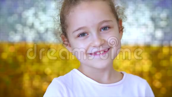 一个绿眼睛的小女孩的肖像看着镜头背景是白色和金色闪闪发光视频的预览图