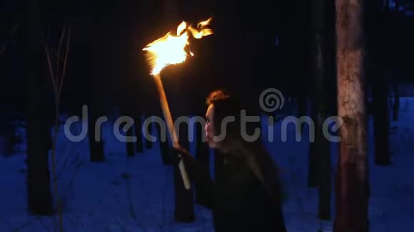 年轻害怕的女人拿着火把从某物上跑出来看着镜头视频的预览图