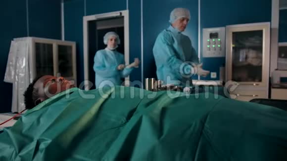 两个穿着特殊长袍的有经验的外科医生来到手术室视频的预览图