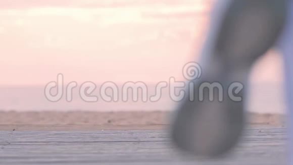 在海边穿着健身服跑步的女人女人沿着木制的人行道跑视频的预览图