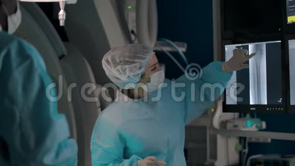女外科医生与手术室的同事一起检查腿部X光视频的预览图