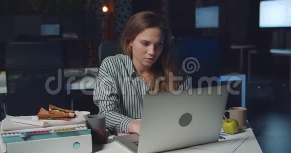 傍晚时分疲惫的年轻女子在笔记本电脑上打字使用个人电脑的女职员视频的预览图