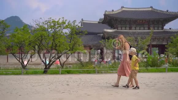 年轻女子和她的小儿子参观了韩国首尔的古代宫殿前往韩国的概念慢镜头视频的预览图