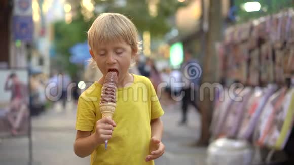 小男孩参观传统的韩国街头市场男孩正在吃一个33厘米长的冰淇淋前往韩国视频的预览图