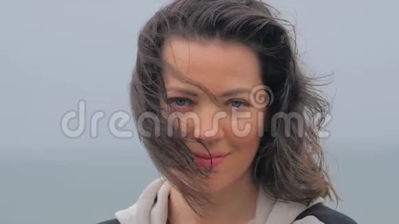 雨天海滩上一个蓝眼睛女人的肖像视频的预览图