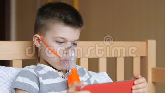 小男孩使用雾化器和玩药片进行治疗性吸入视频的预览图
