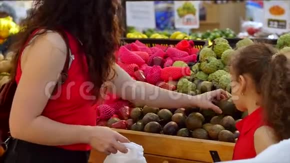 年轻漂亮的女人或母亲孩子或女儿买食物蔬菜鳄梨水果胡萝卜卷心菜沙拉视频的预览图