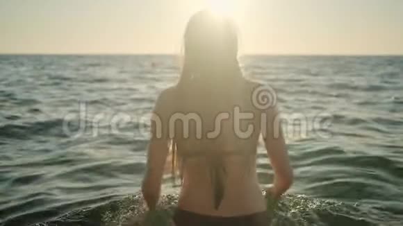 日落时分在海里游泳的女人视频的预览图