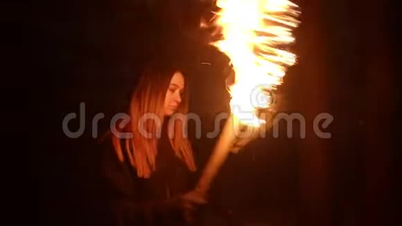 一位年轻女子手持手工火炬在漆黑的冬林中行走视频的预览图