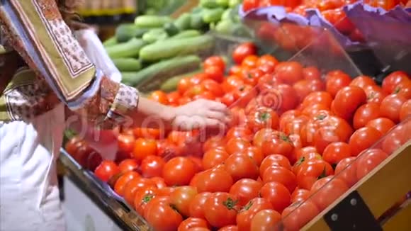 漂亮的年轻女人或母亲在超市购物选择食物西红柿鳄梨水果胡萝卜卷心菜视频的预览图