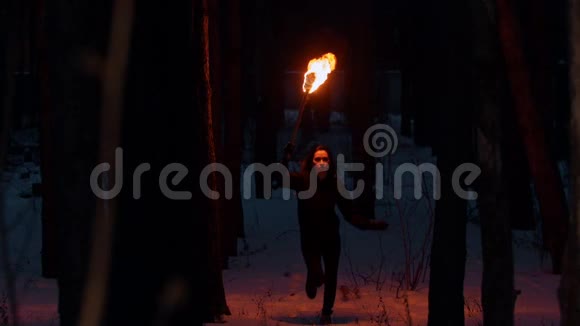 晚上在森林里散步的年轻女子手持火炬视频的预览图