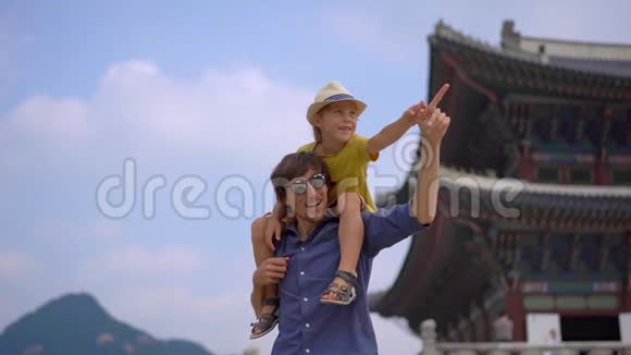 年轻人和他的小儿子参观了韩国首尔的古代宫殿前往韩国的概念慢镜头视频的预览图