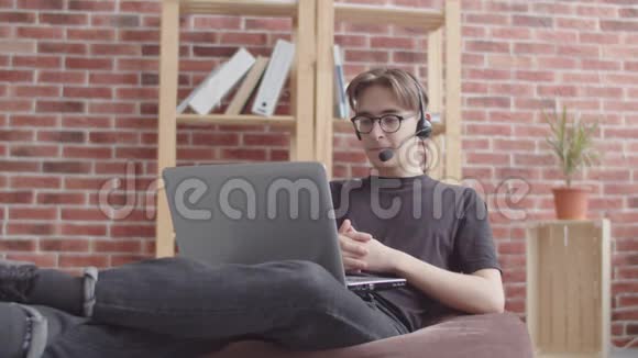 这家伙通过视频聊天交流在网络摄像机前打手势一个自由职业者在家教一个视频的预览图