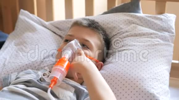 小男孩被用雾化器治疗咳嗽小男孩使用雾化器进行吸入治疗视频的预览图