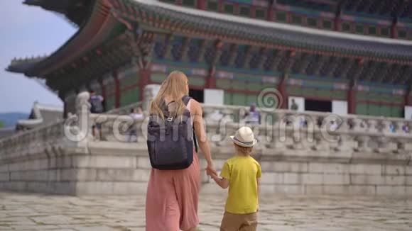 年轻女子和她的小儿子参观了韩国首尔的古代宫殿前往韩国的概念慢镜头视频的预览图