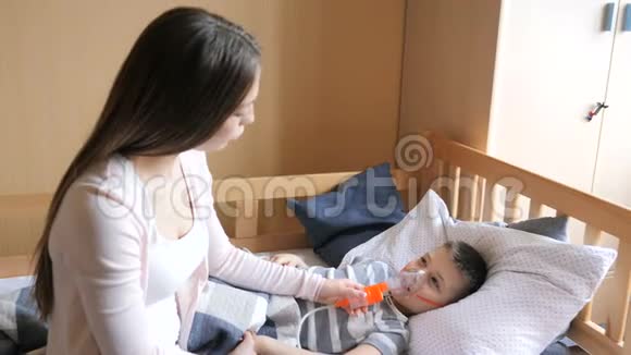 妈妈和小男孩用喷雾器吸药视频的预览图